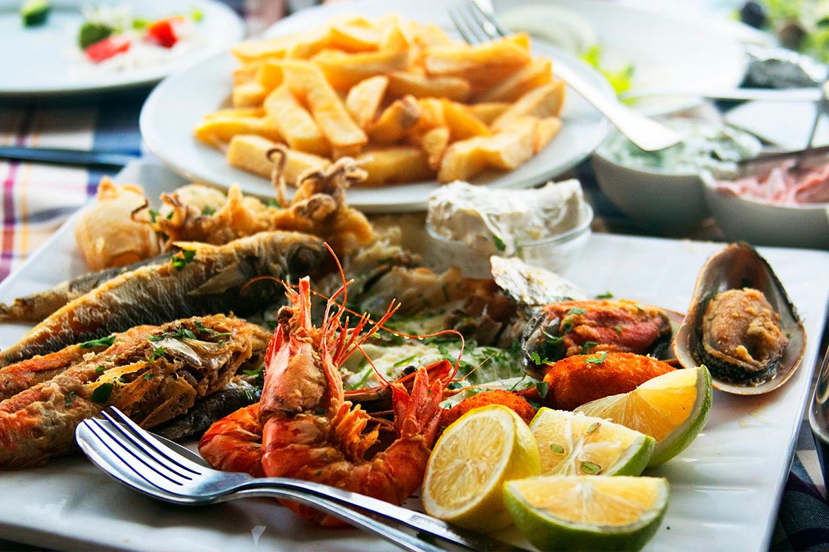 Verschiedene Speisen von Fisch bis Meeresfrüchte auf einem gedeckten Tisch im Bootshaus Binz.