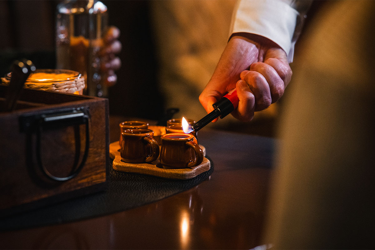 Traditioneller Grog wird im Bootshaus Binz auf Rügen serviert – rustikales Ambiente mit Holztisch und Kerzenlicht.